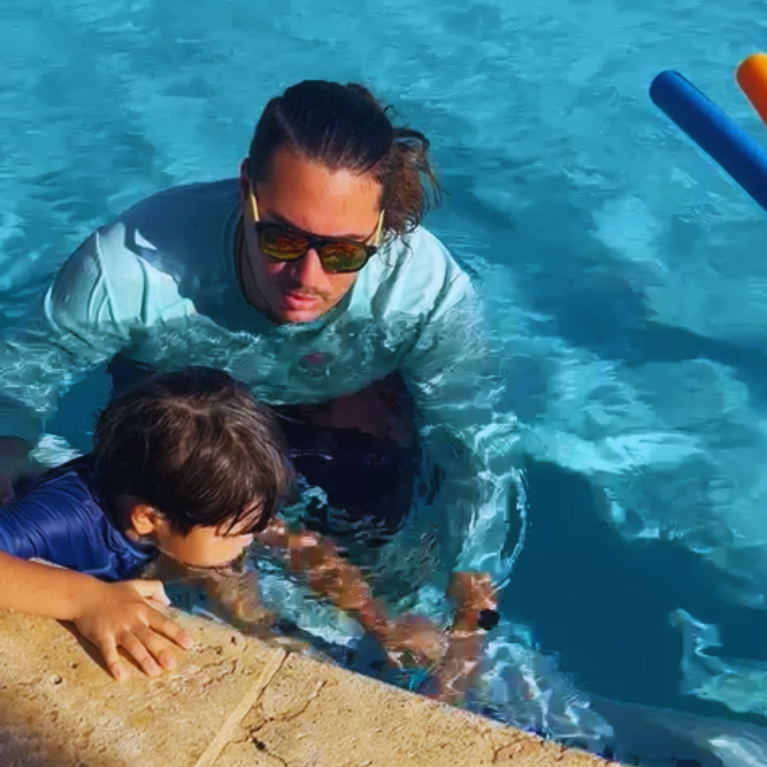 Instructor dando clases para aprender a nadar a un niño